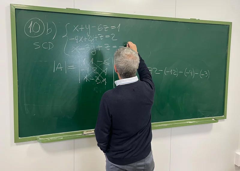 Profesor con pizarron verde
